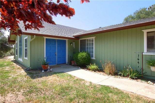 exterior space featuring a yard and a shingled roof