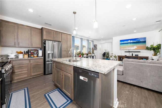kitchen with visible vents, a sink, open floor plan, dark wood-style flooring, and appliances with stainless steel finishes
