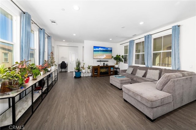 living area featuring dark wood-style flooring, visible vents, and recessed lighting