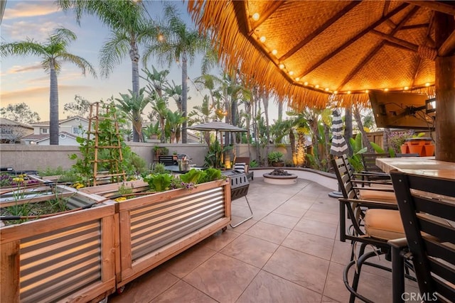 view of patio / terrace featuring outdoor dining space, fence, and an outdoor fire pit