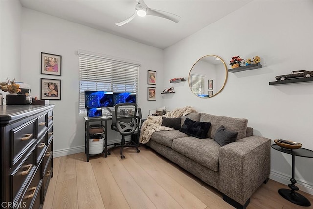 office space with light wood-style floors, baseboards, and a ceiling fan