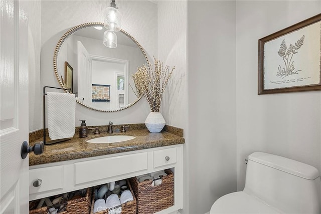 half bathroom with vanity and toilet