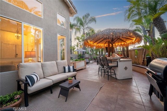 view of patio with outdoor dry bar, fence, area for grilling, and an outdoor hangout area