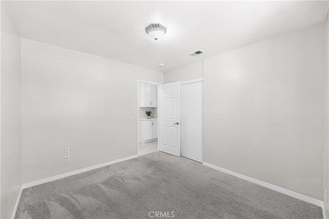 unfurnished room with light carpet, baseboards, and visible vents