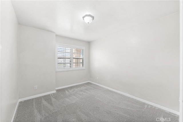 carpeted spare room with baseboards