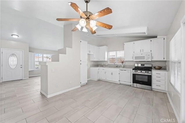 kitchen featuring light countertops, white appliances, vaulted ceiling, and a healthy amount of sunlight