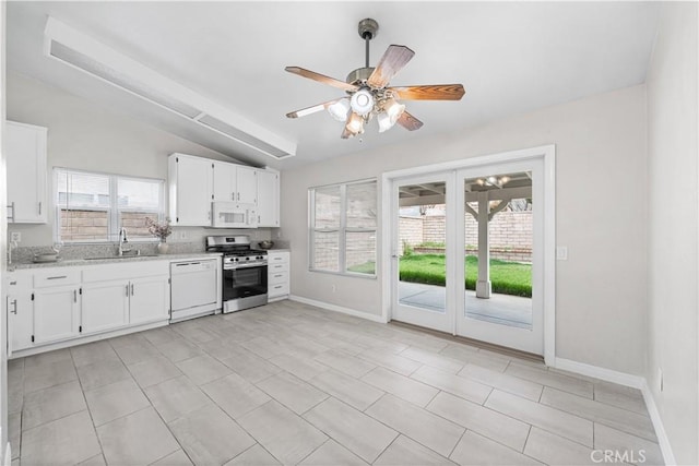 kitchen with white appliances, a ceiling fan, white cabinetry, vaulted ceiling, and a sink