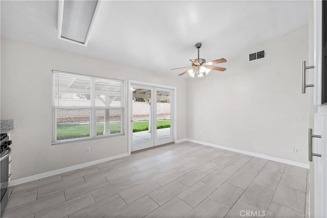 spare room featuring visible vents, ceiling fan, attic access, and baseboards