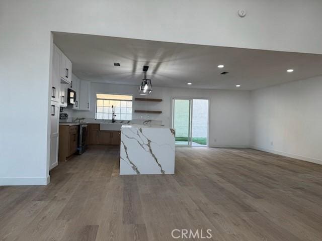 kitchen featuring light wood-style flooring, electric stove, a healthy amount of sunlight, and a sink