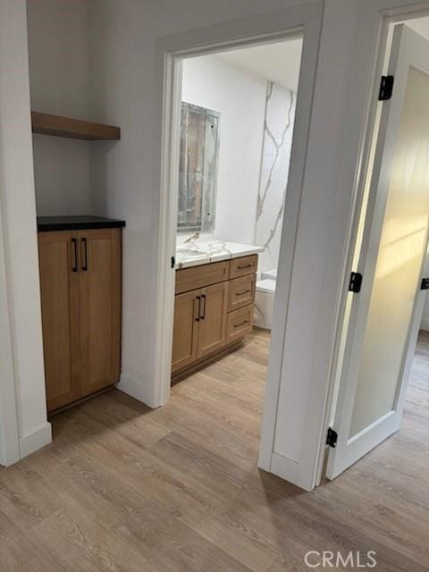 bathroom with baseboards, vanity, and wood finished floors