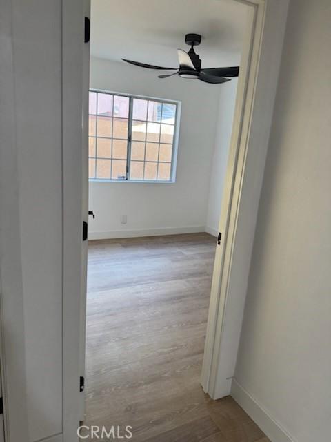 hallway featuring baseboards and wood finished floors