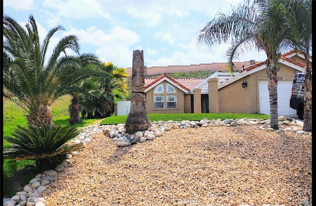 view of front of house with a garage, stucco siding, and a tile roof
