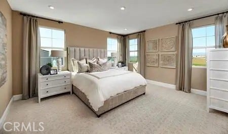 bedroom featuring light colored carpet, baseboards, and multiple windows