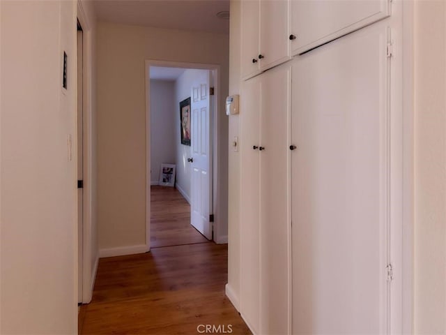 hallway with baseboards and light wood-style floors