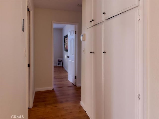 hallway with light wood-style floors and baseboards
