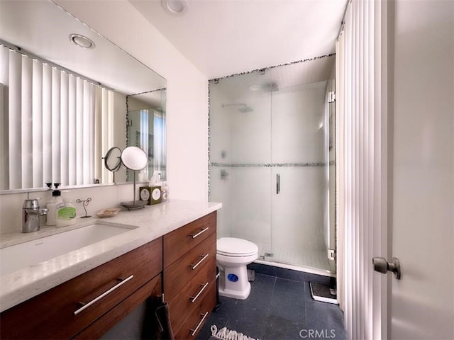 full bathroom with a stall shower, vanity, tile patterned flooring, and toilet