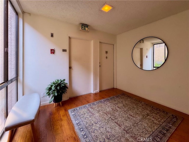 entrance foyer featuring wood finished floors, a textured ceiling, and baseboards