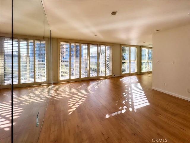 unfurnished living room featuring wood finished floors and baseboards