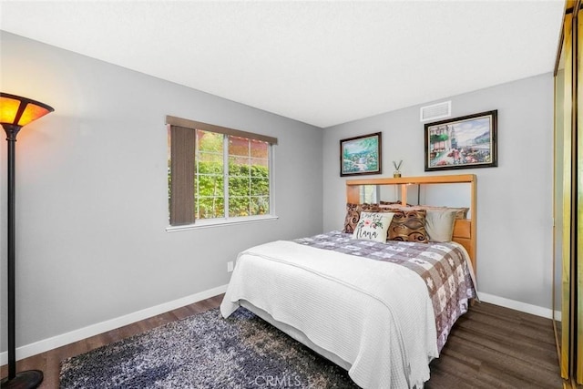 bedroom with visible vents, baseboards, and wood finished floors