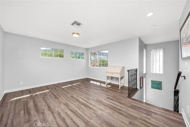 unfurnished room with visible vents, baseboards, and wood finished floors
