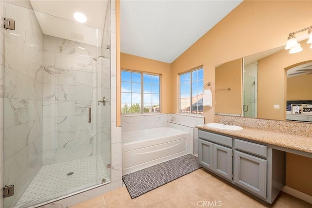 full bathroom with vanity, vaulted ceiling, tile patterned flooring, a shower stall, and a garden tub