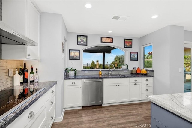 kitchen with visible vents, a sink, dark wood-style flooring, stainless steel dishwasher, and decorative backsplash