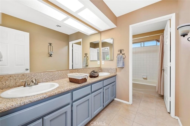 bathroom with tile patterned floors, double vanity, baseboards, and a sink