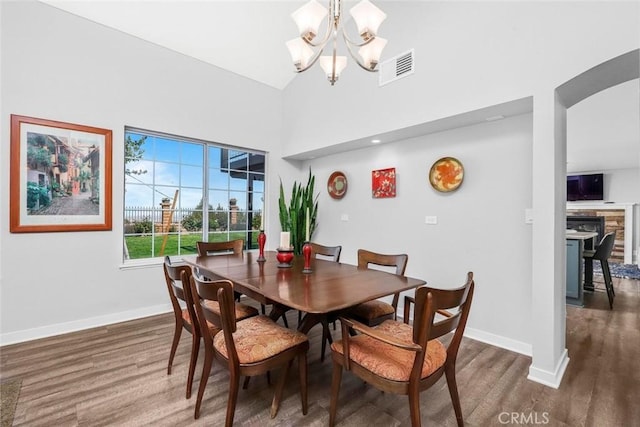 dining space with a chandelier, visible vents, baseboards, and wood finished floors