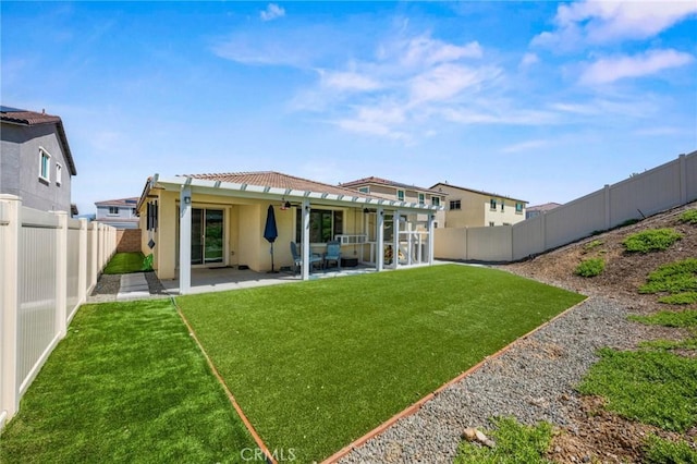 back of property featuring a yard, stucco siding, a fenced backyard, and a patio