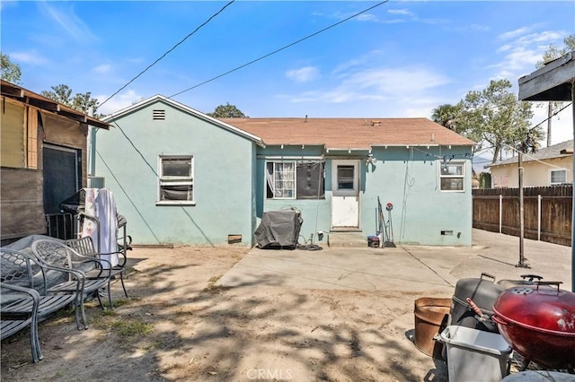 rear view of house with a patio, fence, entry steps, and stucco siding