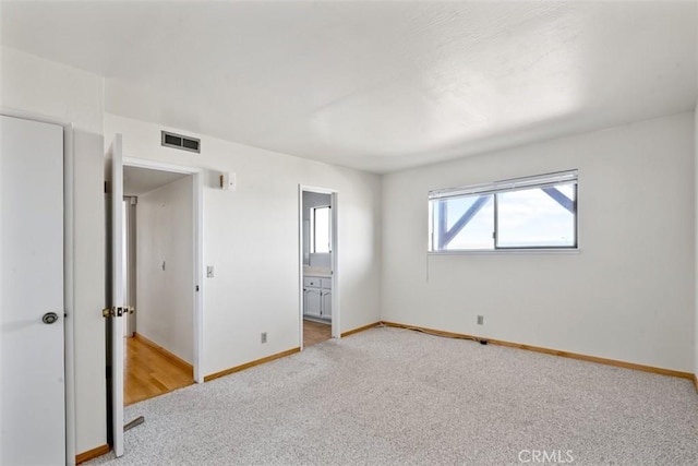 empty room with visible vents, baseboards, and light carpet