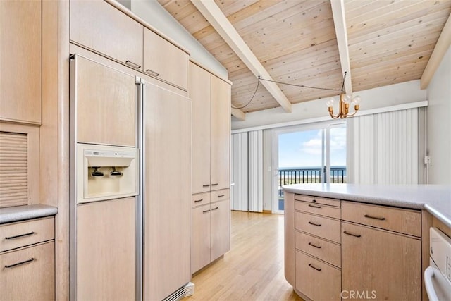 kitchen with light brown cabinets, light wood-style floors, light countertops, paneled refrigerator, and a chandelier