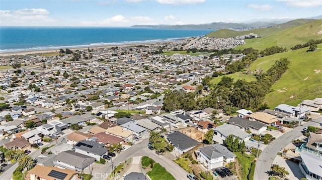 drone / aerial view featuring a water view, a beach view, and a residential view