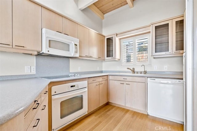kitchen with white appliances, light countertops, beam ceiling, and light brown cabinets
