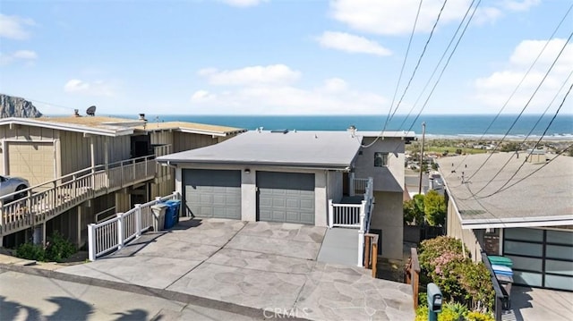 view of front of house with a garage, fence, a water view, and driveway