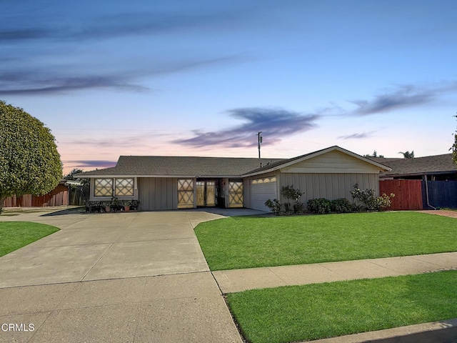 single story home with a lawn, driveway, a garage, and fence