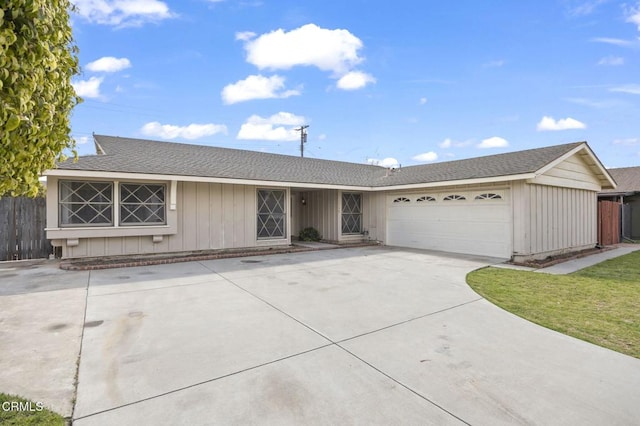 ranch-style house featuring driveway, a shingled roof, an attached garage, and fence