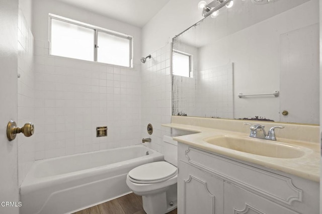 bathroom featuring toilet, vanity, shower / bathtub combination, and wood finished floors