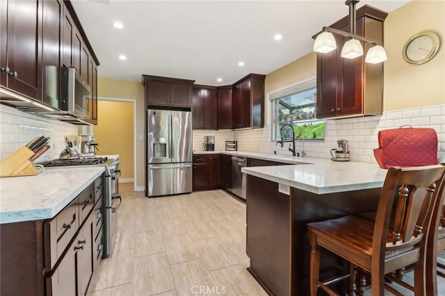 1460 E Glenoaks Blvd, Glendale, CA 91206 - kitchen featuring stainless steel appliances, a peninsula, decorative backsplash, a breakfast bar area, and recessed lighting