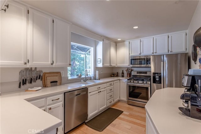 381 Old Toll Rd, Lake Arrowhead, CA 92317 - kitchen featuring light countertops, white cabinets, light wood-style floors, appliances with stainless steel finishes, and a sink
