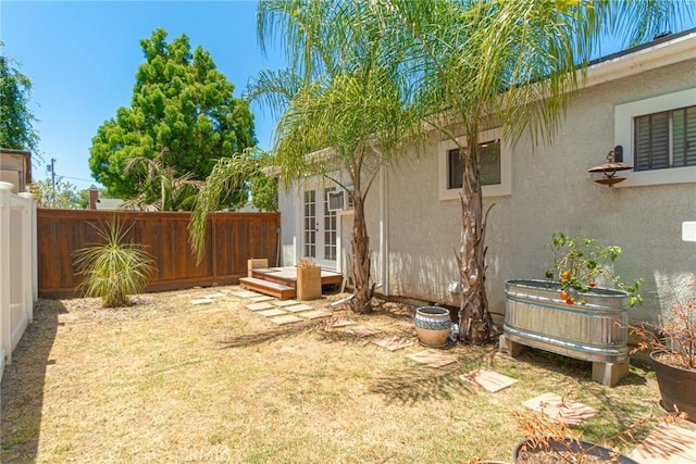 view of yard with french doors and a fenced backyard