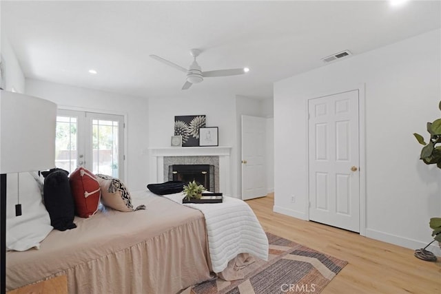 bedroom featuring a fireplace, recessed lighting, light wood-style flooring, visible vents, and access to exterior