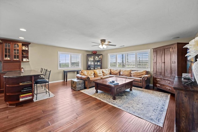 living room with plenty of natural light, baseboards, a ceiling fan, and wood finished floors