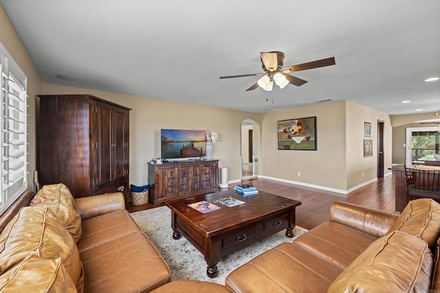 living room with baseboards, recessed lighting, a ceiling fan, arched walkways, and wood finished floors