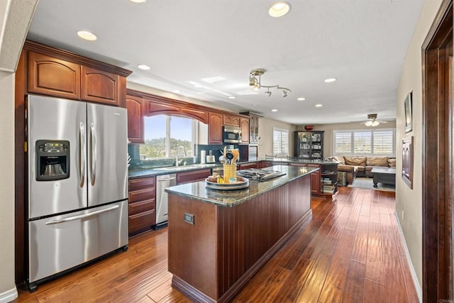kitchen with a wealth of natural light, recessed lighting, a center island, and appliances with stainless steel finishes