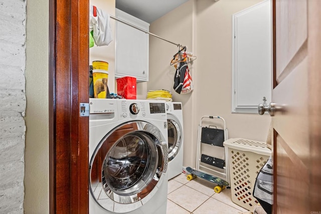 laundry room with cabinet space, washer and clothes dryer, and light tile patterned flooring