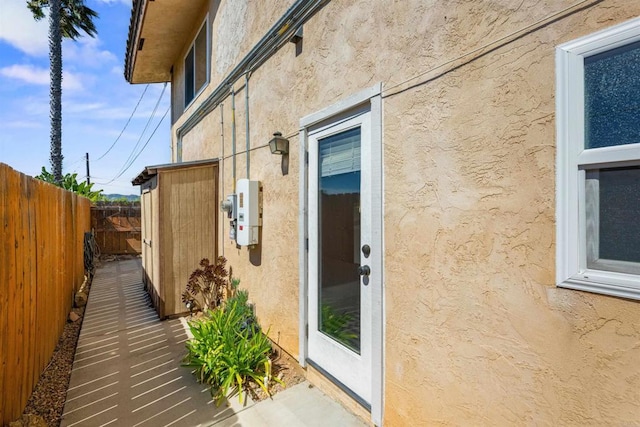 view of side of property featuring stucco siding and fence