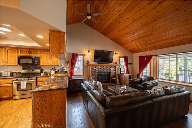 living room featuring a ceiling fan, wooden ceiling, light wood-type flooring, a brick fireplace, and high vaulted ceiling