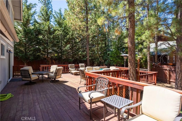 wooden terrace with a fenced backyard and outdoor dining area
