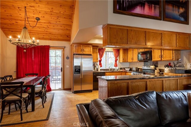 kitchen featuring black appliances, brown cabinets, dark countertops, and a peninsula